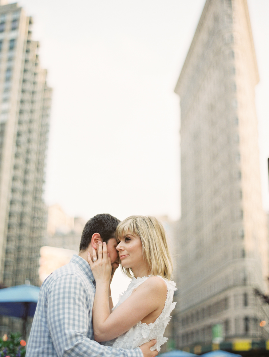 couple standing close in front of Flatiron building in New York City by Mary Dougherty