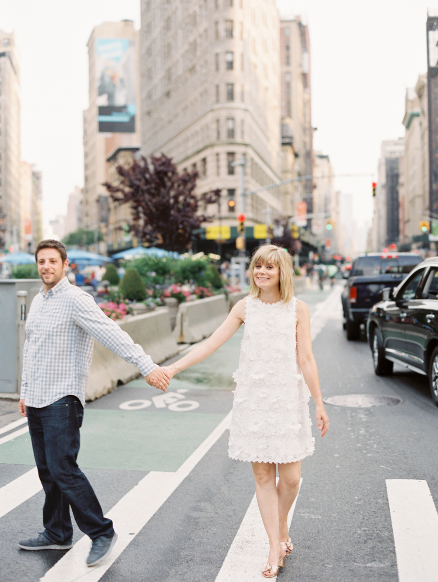 Engaged couple walking in front of Flatiron building in NYC photo by Mary Dougherty
