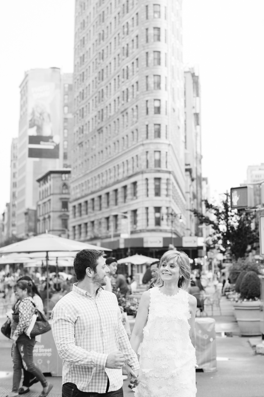 Engaged couple walking in front of Flatiron building in NYC bw photo by Mary Dougherty