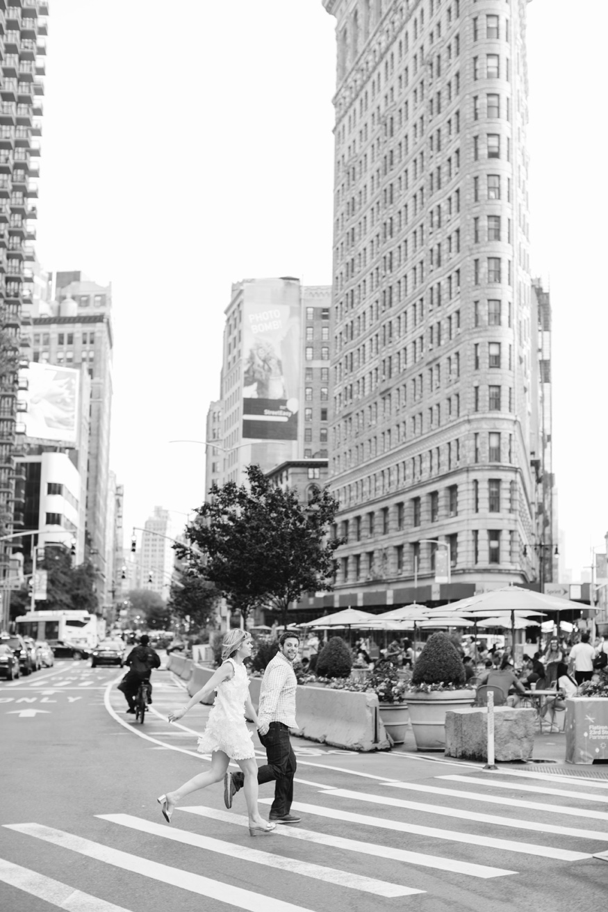couple running in front of the Flatiron Building in NYC by Mary Dougherty