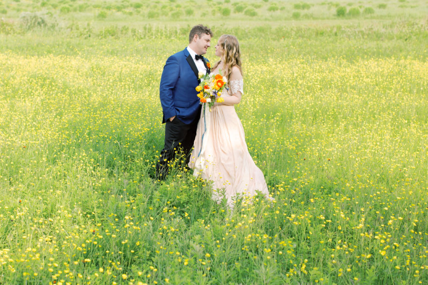 bride and groom standing in field of golden yellow flowers | Mary Dougherty