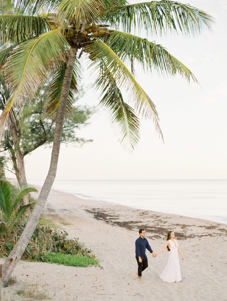 couple walking under palm tree in Delray Beach Florida next to ocean | Mary Dougherty