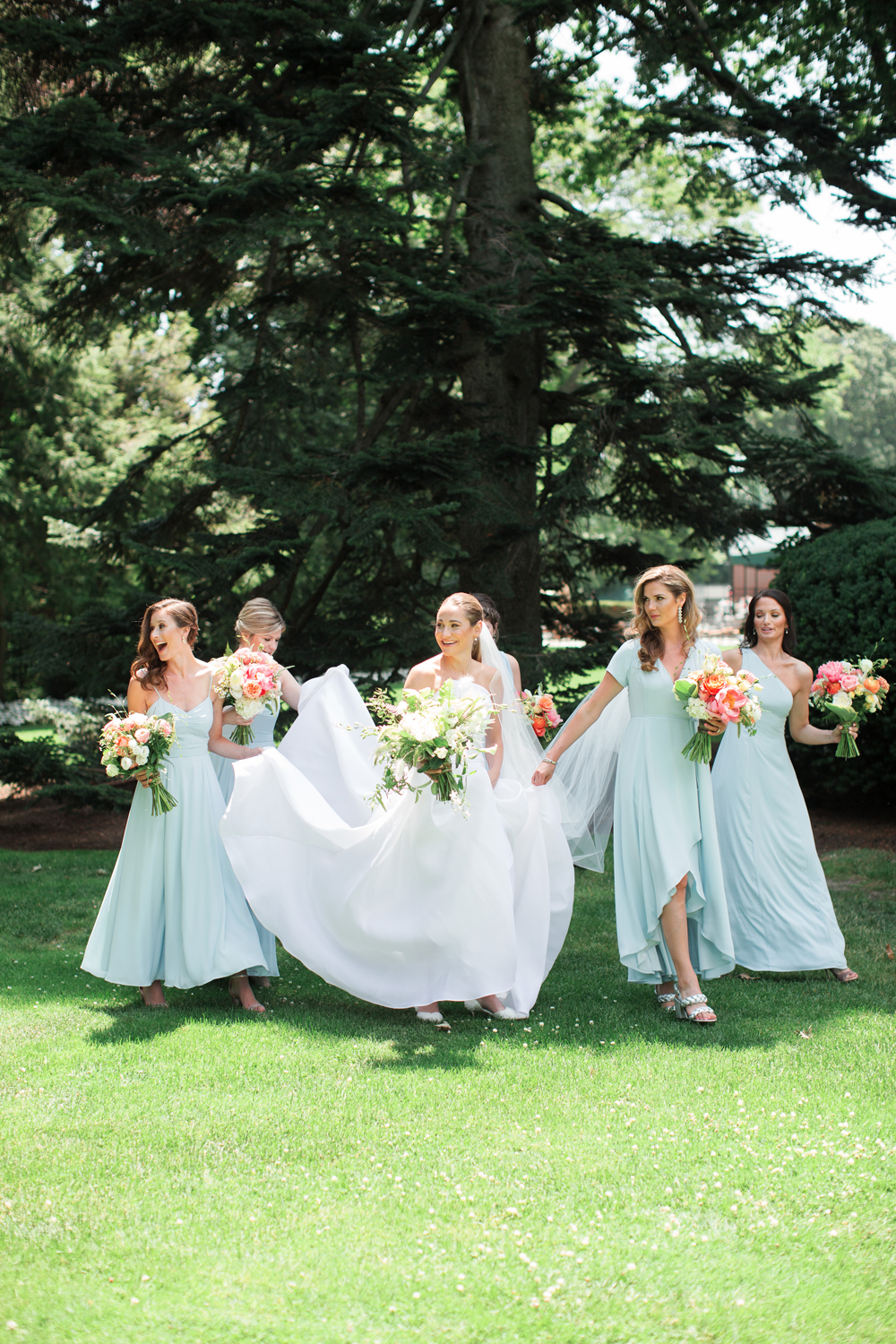 Bridesmaids help bride walk at Genesee Valley club on wedding day with blue dresses and modern design | Mary Dougherty Photography