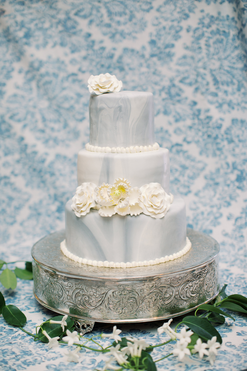 marbled blue wedding cake with sugar flowers and custom linen backdrop at Genesee Valley club | Mary Dougherty