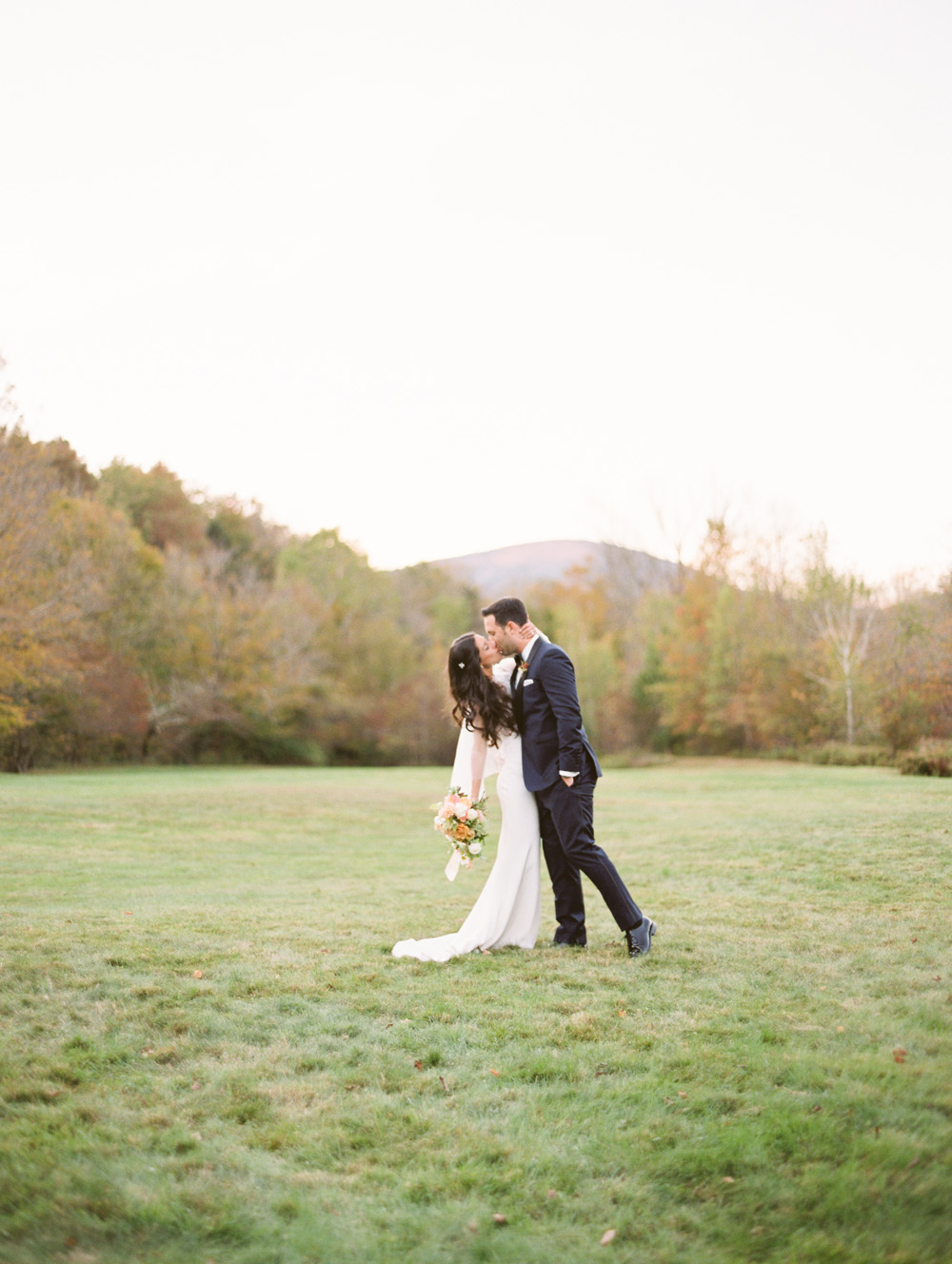 Kiss in the field at Full Moon Resort after their ceremony | Mary Dougherty