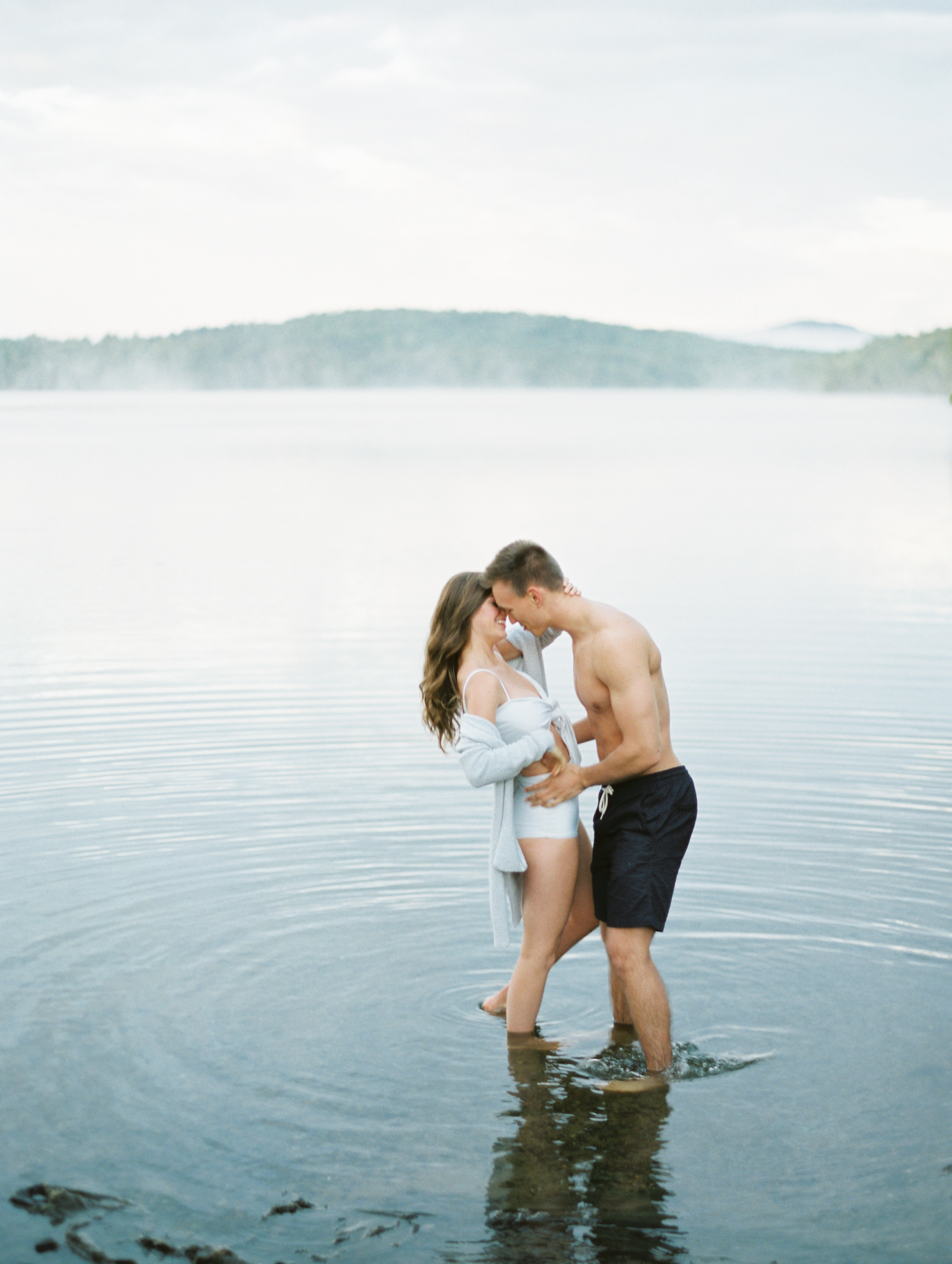 couples stands and kisses in water in Adirondacks Old Forge, Lake Placid, Saranac Lake, Keene adventure Mary Dougherty