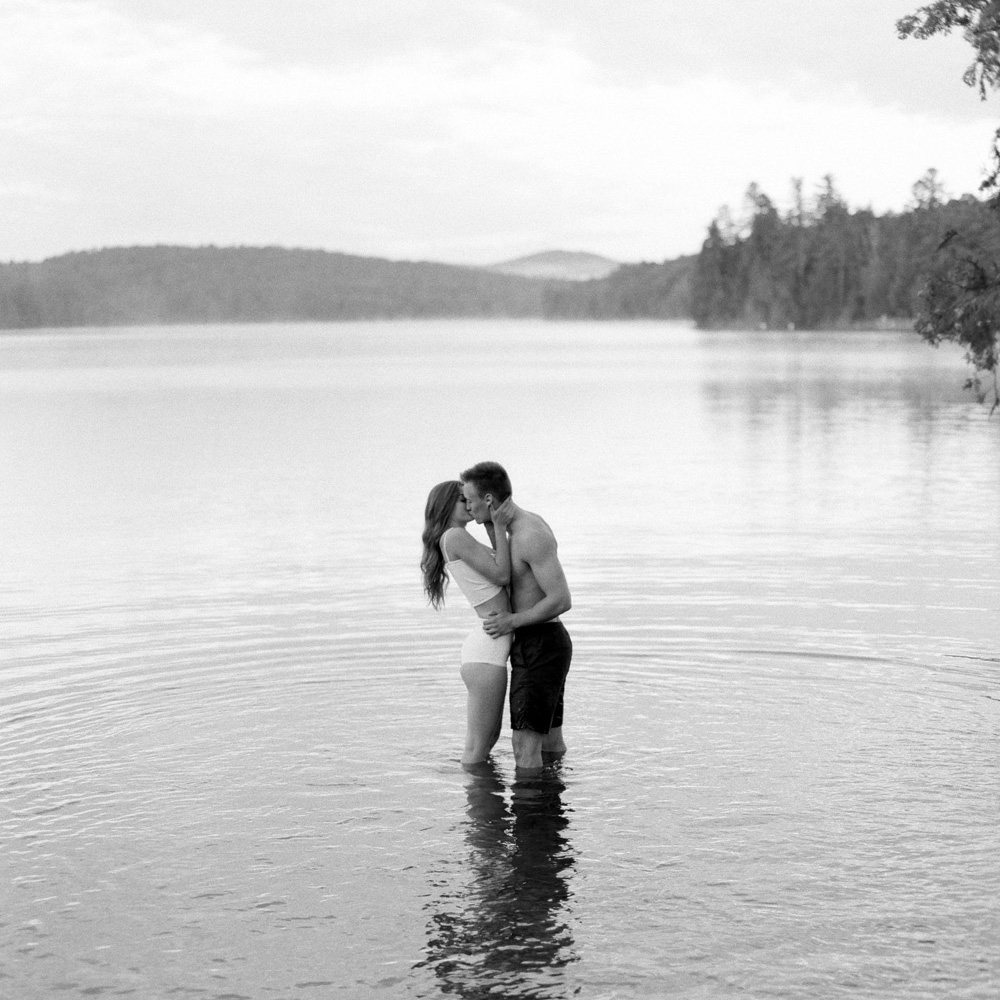 bw image of couple kissing in water in Saranac Lake, New York Adirondacks | Mary Dougherty Photography