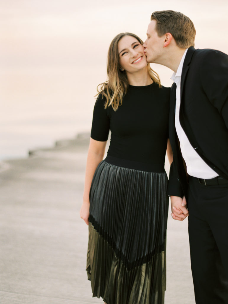 couple kiss on the cheek in Chicago engagement photo by film wedding photographer Mary Dougherty