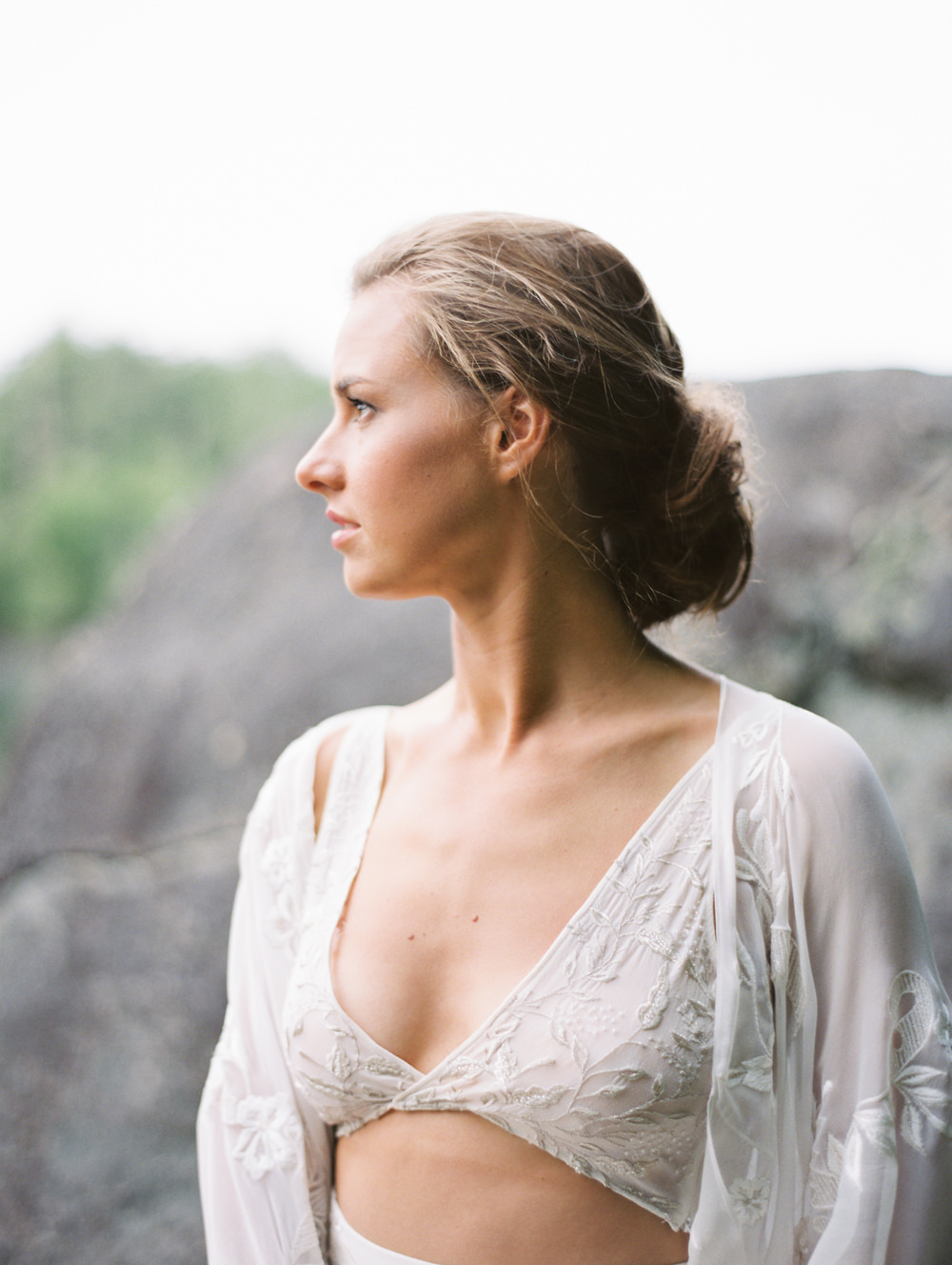 bride looks out with natural wedding makeup look and messy bun in three piece wedding dress modern bohemian by Mary Dougherty