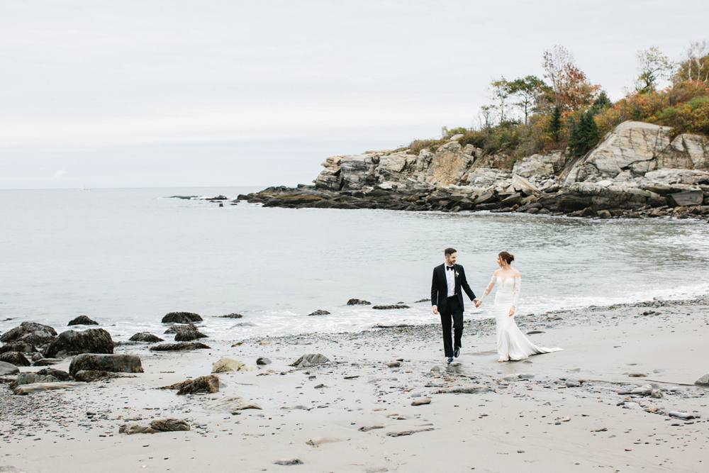 bride and groom walk on Portland Head Light Beach during their Maine fall elopement | Mary Dougherty 