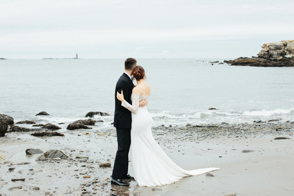 bride and groom look to water at Portland Head Light Beach during their Maine fall elopement | Mary Dougherty 