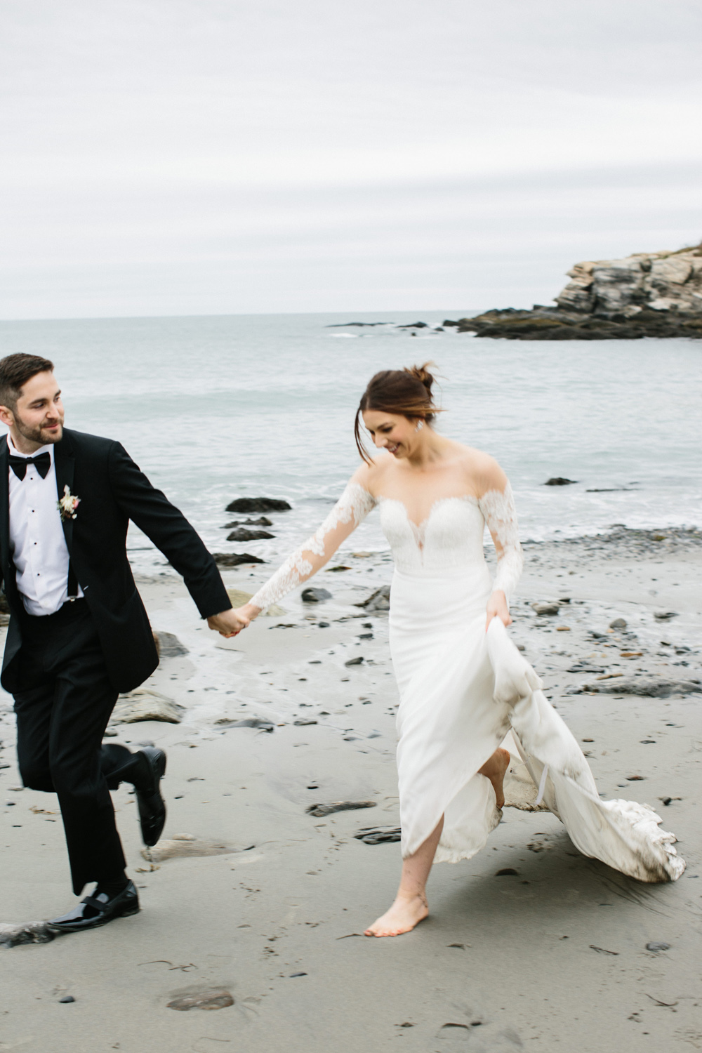 bride and groom run on Portland Head Light Beach during their Maine fall elopement | Mary Dougherty 