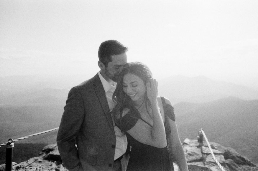 couple laughs in black and white photo on top of mountain in adirondacks by Mary Dougherty