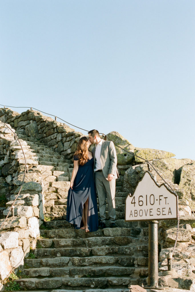 whiteface mountain sea level sign 4610ft above sea with couple standing on rocky staircase kissing by Mary Dougherty lake placid wedding photographer