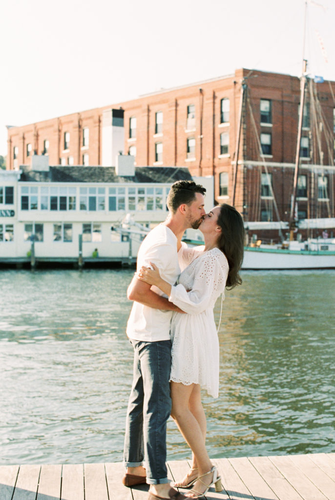 Beach engagement photos with couple standing on a dock