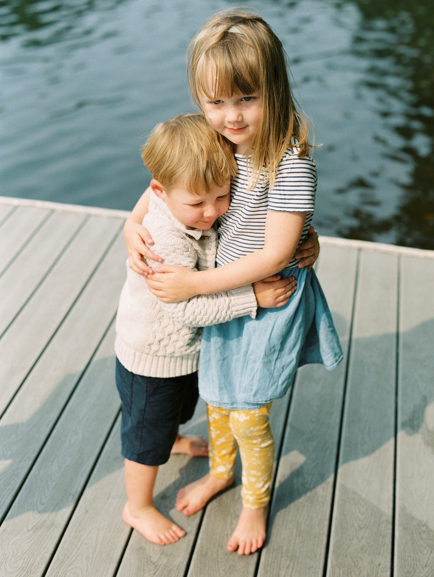 brother and sister hug family photos on Upper St. Regis Lake in the Adirondacks