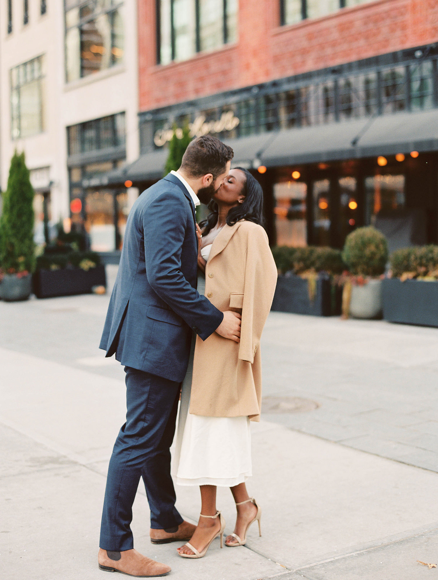 Soon-to-be married couple embracing outside of the Shinola Hotel Detroit