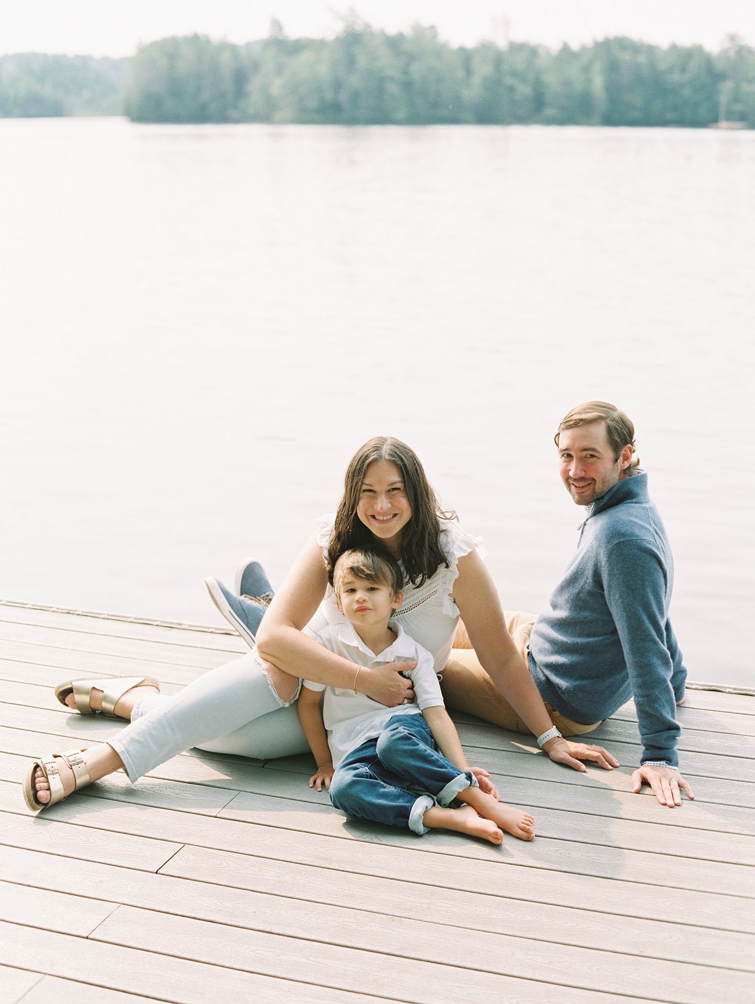 family sitting on a dock in the Adirondacks 