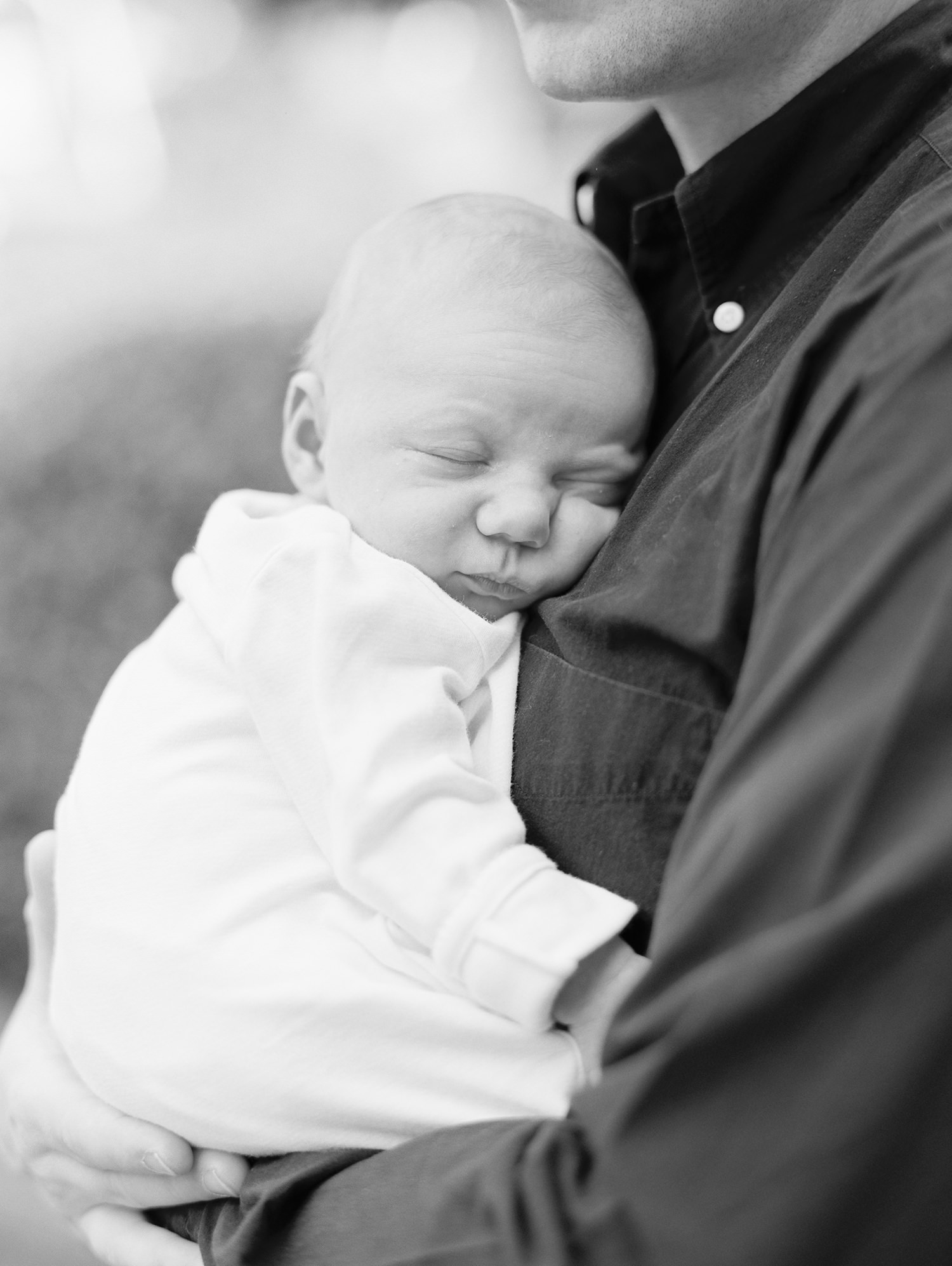 Newborn sleeps while dad holds him by Mary Dougherty