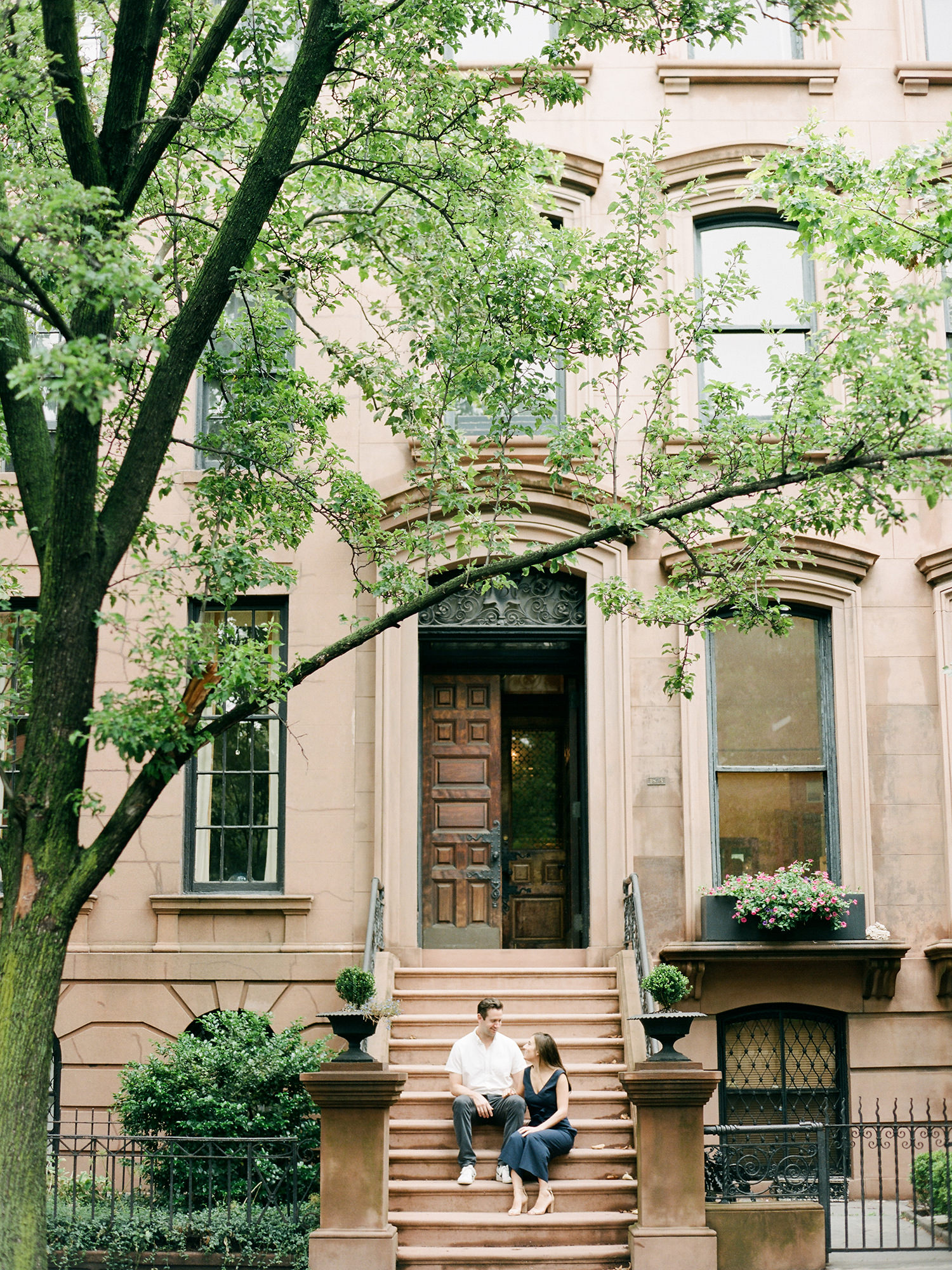 Brooklyn Heights Brownstone engagement photo with couple sitting on steps. Film photograph by Mary Dougherty