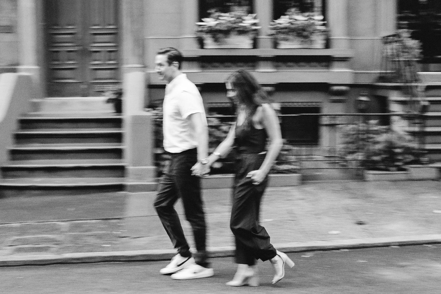 black and white image with motion blur of couple walking during engagement photos in Brooklyn Heights