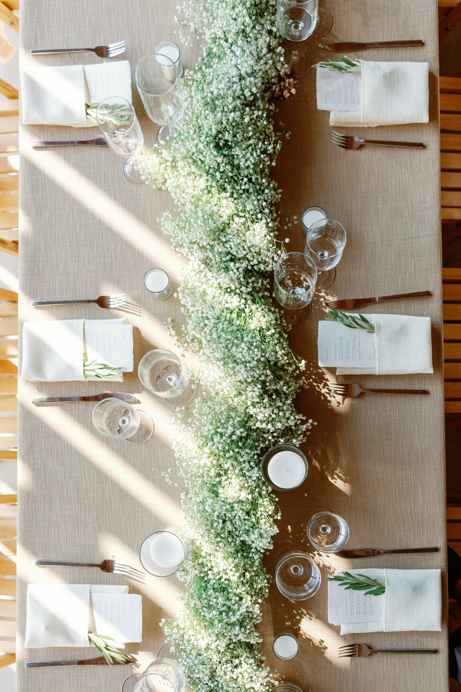 overhead shot of table design set for wedding reception at Gather Greene with baby's breath runner and simple elegant design